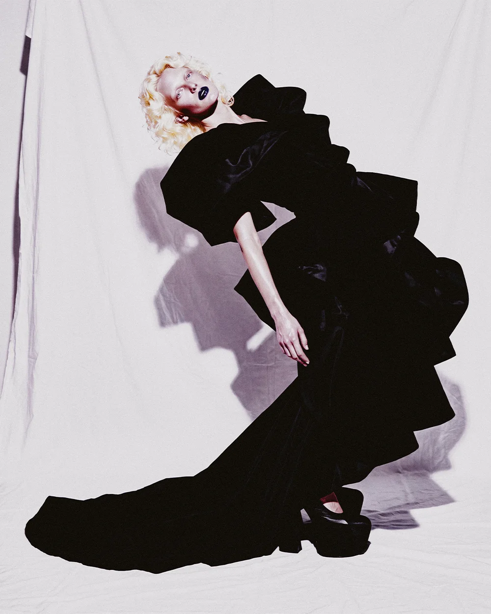 Color Full-length editorial of Elena arched backward in a black velvet gown with train against a white backdrop – Sbranzo Alessandro Valori Studio Vago Elena