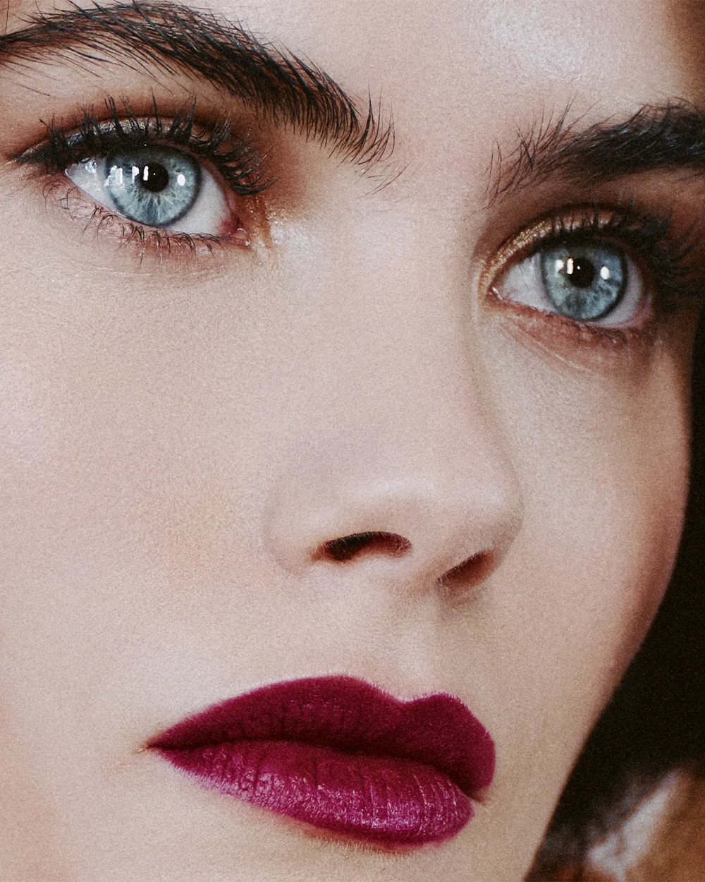 Editorial beauty close-up of a model with striking blue eyes and deep plum lips – Fabiani Gioiellerie – Sbranzo Alessandro Valori Studio Vago Gaia Schiralli