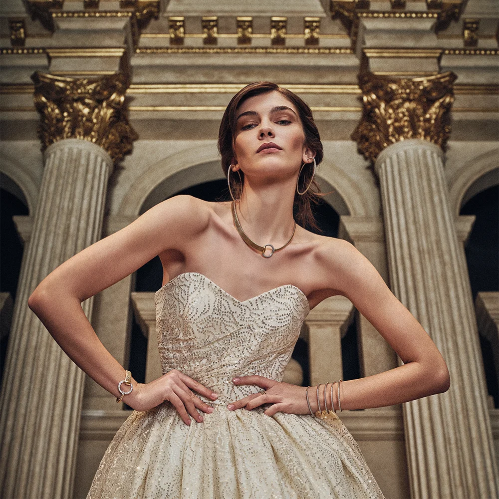 Fashion jewelry editorial 999 – model in a strapless embellished gown wearing hoop earrings, necklace and bracelets against gilded neoclassical columns – Sbranzo Alessandro Valori Studio Vago Tati Janusheva