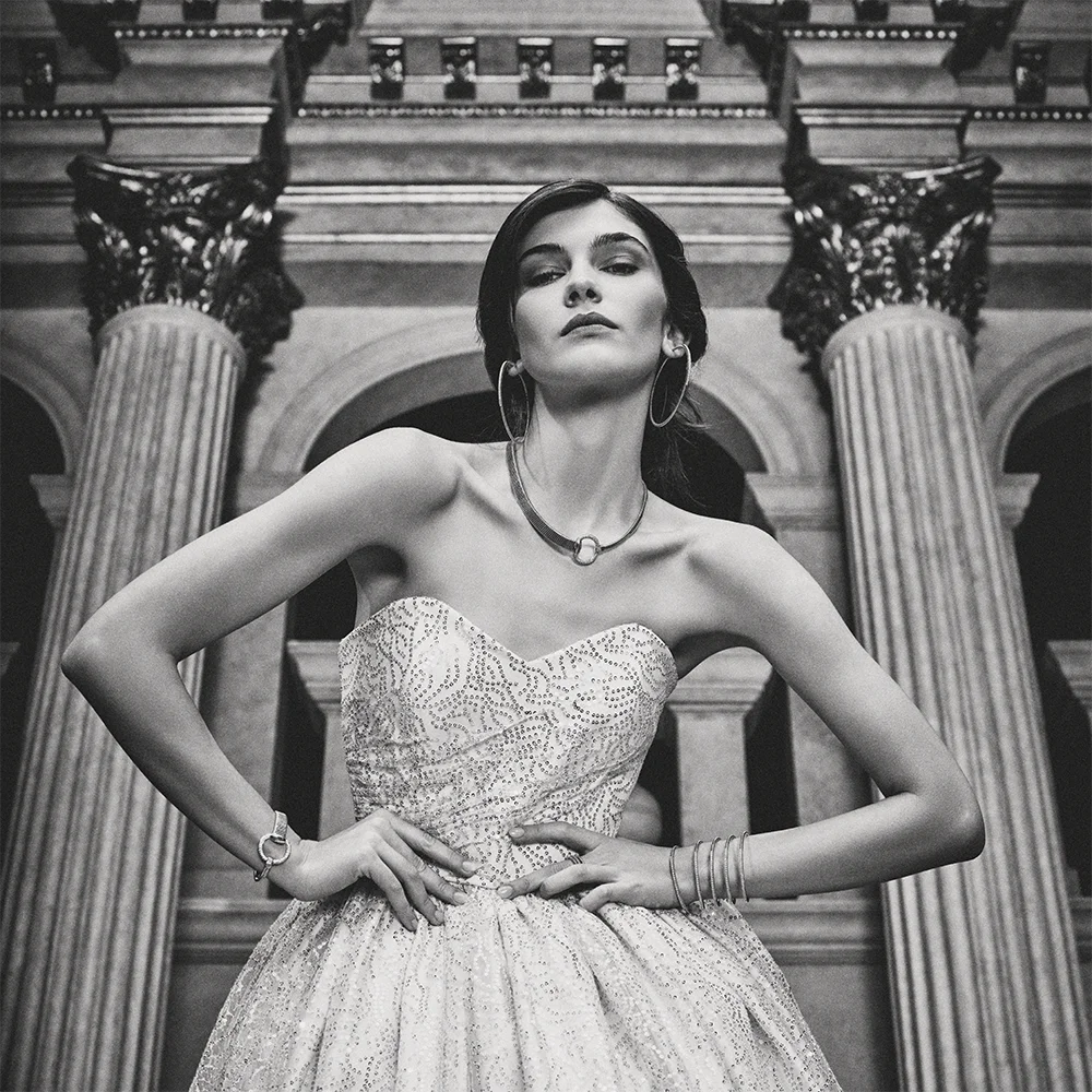Black and white fashion jewelry editorial 999 – model in a strapless embellished gown wearing hoop earrings, necklace and bracelets against neoclassical columns – Sbranzo Alessandro Valori Studio Vago Tati Janusheva